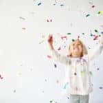 Ecstatic little girl catching falling confetti