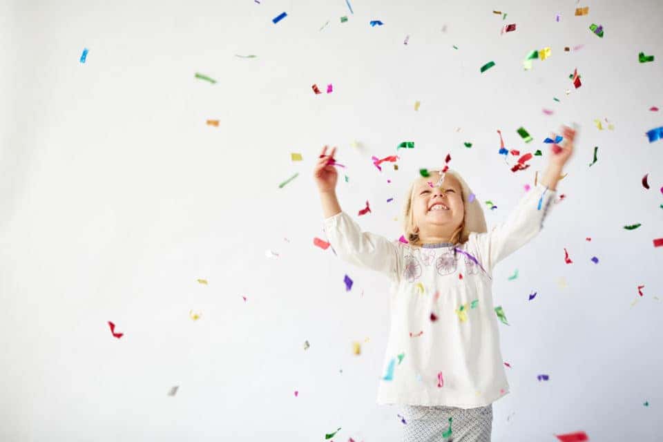 Ecstatic little girl catching falling confetti