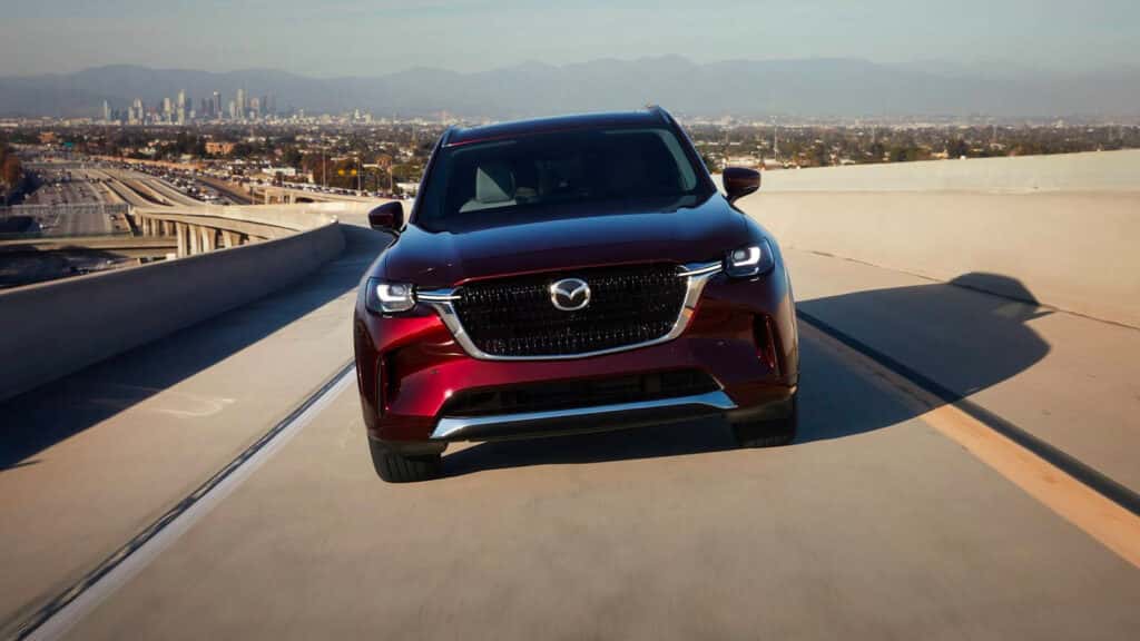Red Mazda SUV driving on the road