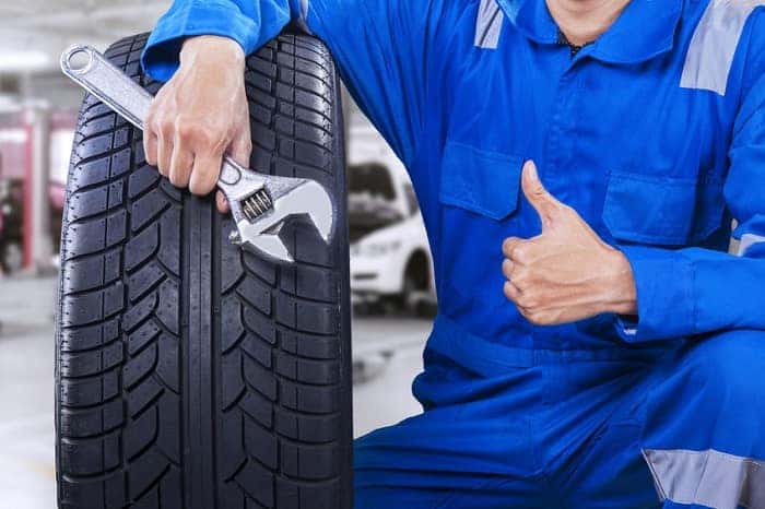 Mechanic giving thumbs up with Mazda tires
