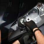 Mazda service technician working on a headlight