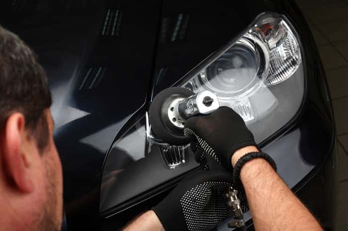 Mazda service technician working on a headlight