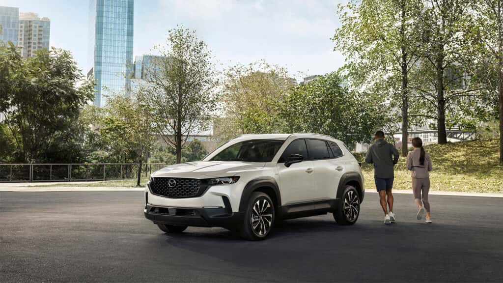 Family walking toward parked Mazda SUVs