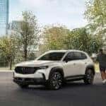 Family walking toward parked Mazda SUVs