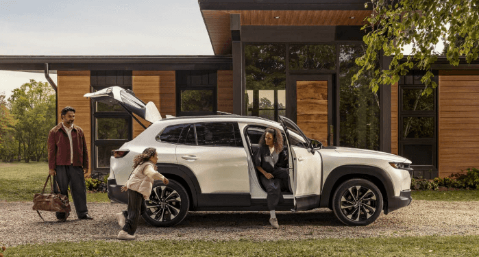 Family getting out of white 2026 MAZDA CX-50 Hybrid.