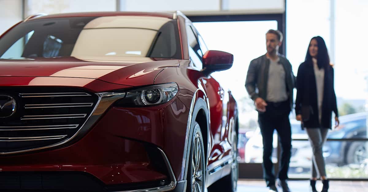 Customers walking through the showroom at a Mazda dealership