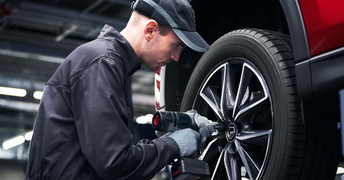 Mazda service technician working on a tire