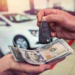 Cash and keys exchanging hands as part of Mazda trade-in