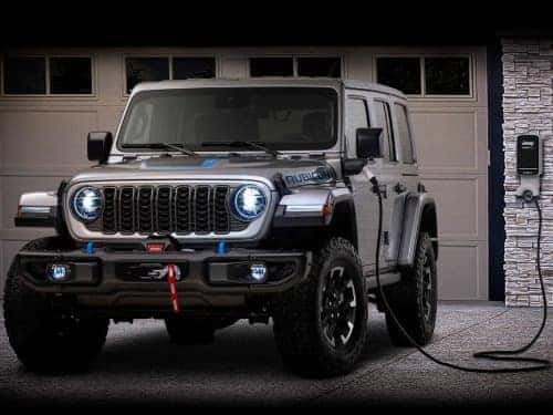 2024 Jeep Wrangler 4xe charging outside of a home