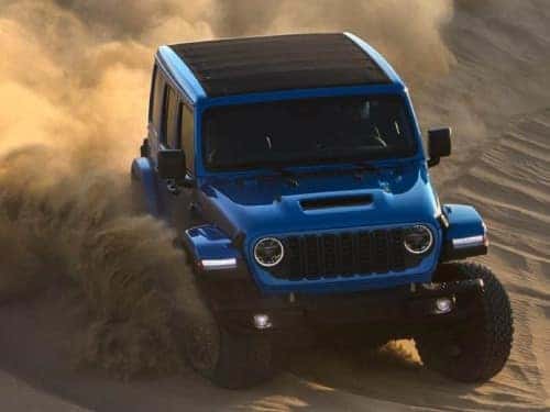 2024 Jeep Wrangler 4xe driving through sand