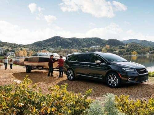 2024 Chrysler Pacifica towing a boat next to a lake