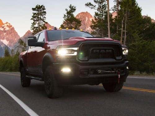 2024 RAM 2500 driving on a highway with mountains in the background