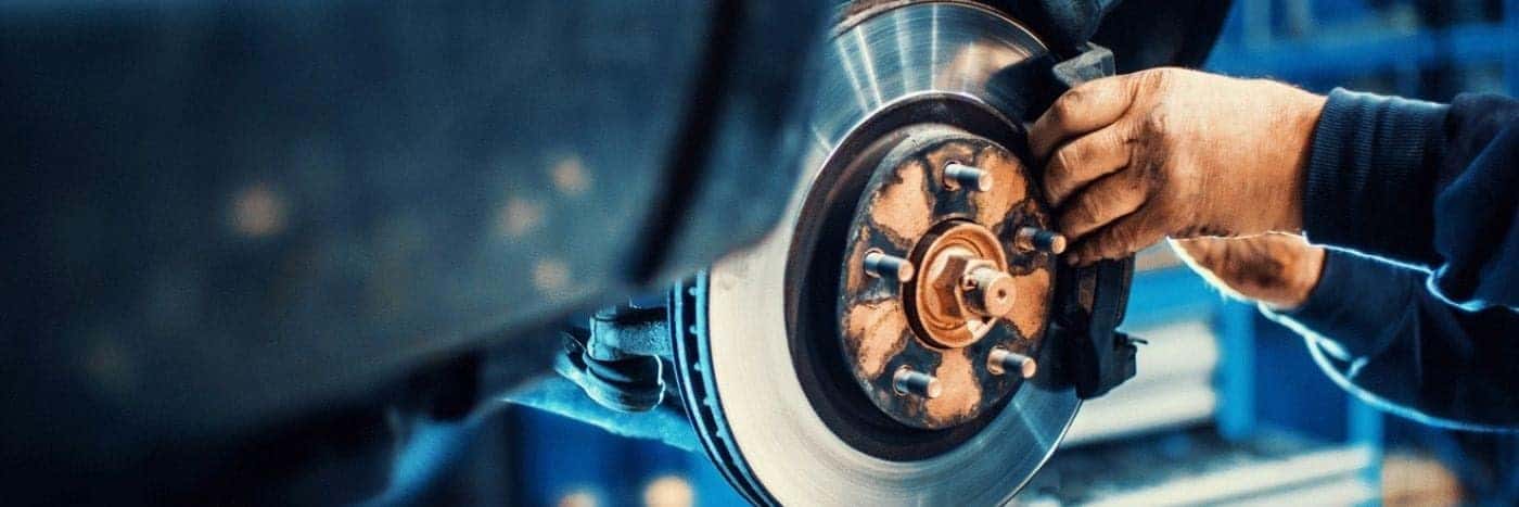 close up view of a service tech checking out a brake rotor