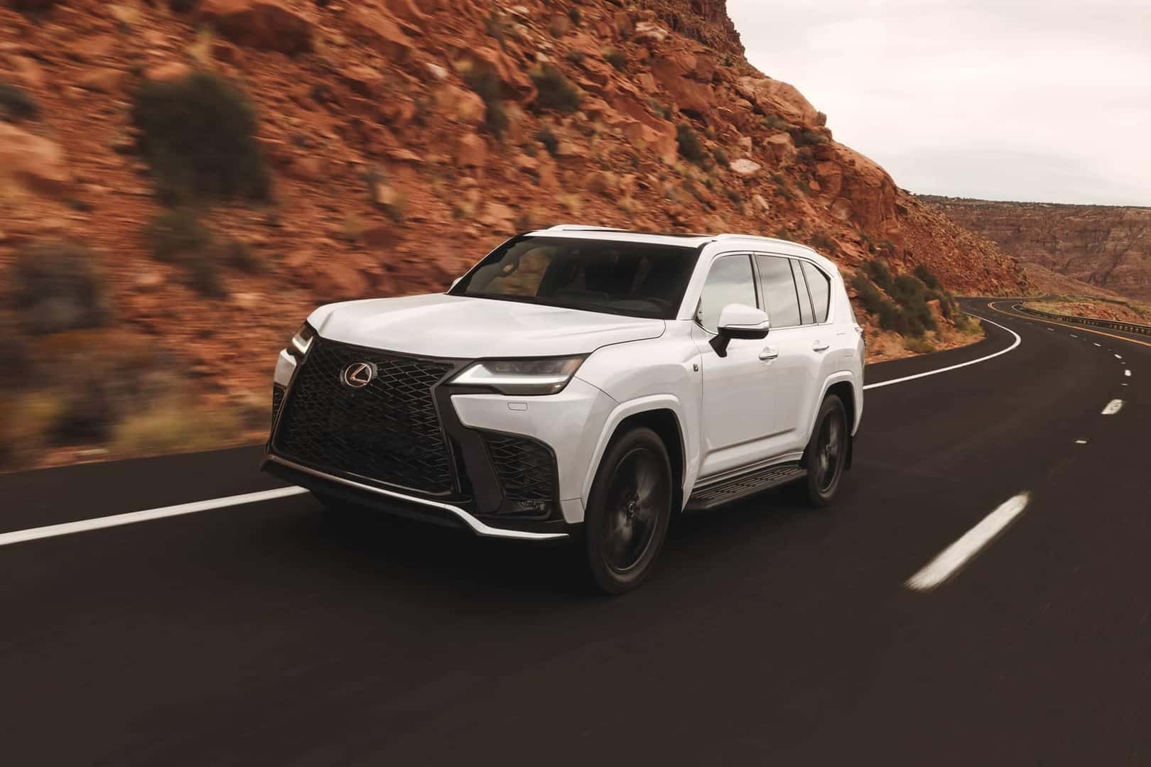 2026 lexus lx driving on road next to mountain