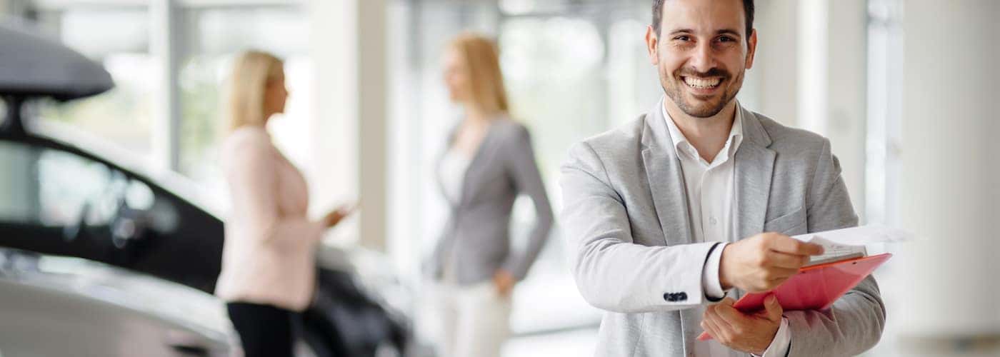 car salesman at dealership with contract