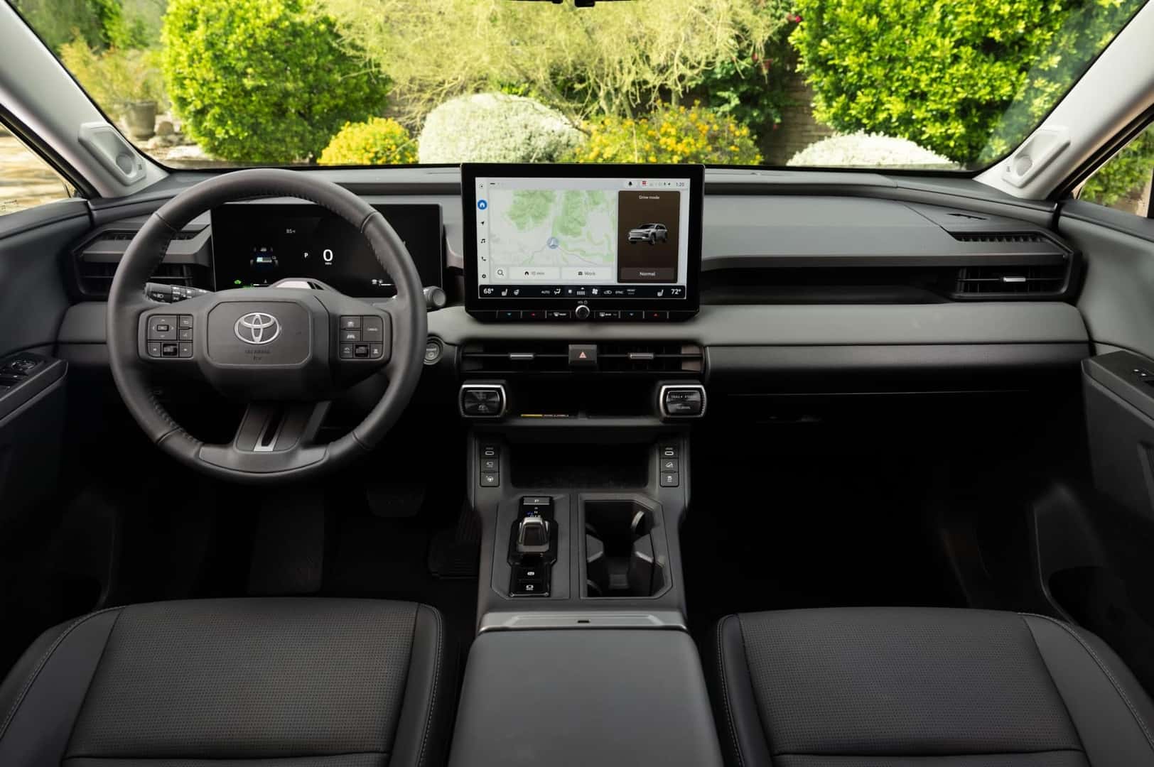 The Sleek Black Front Interior Of The Fabulous And Astonishing 2026 Toyota RAV4 Limited, With Green Scenery Viewable Through The Clear Front Windshield