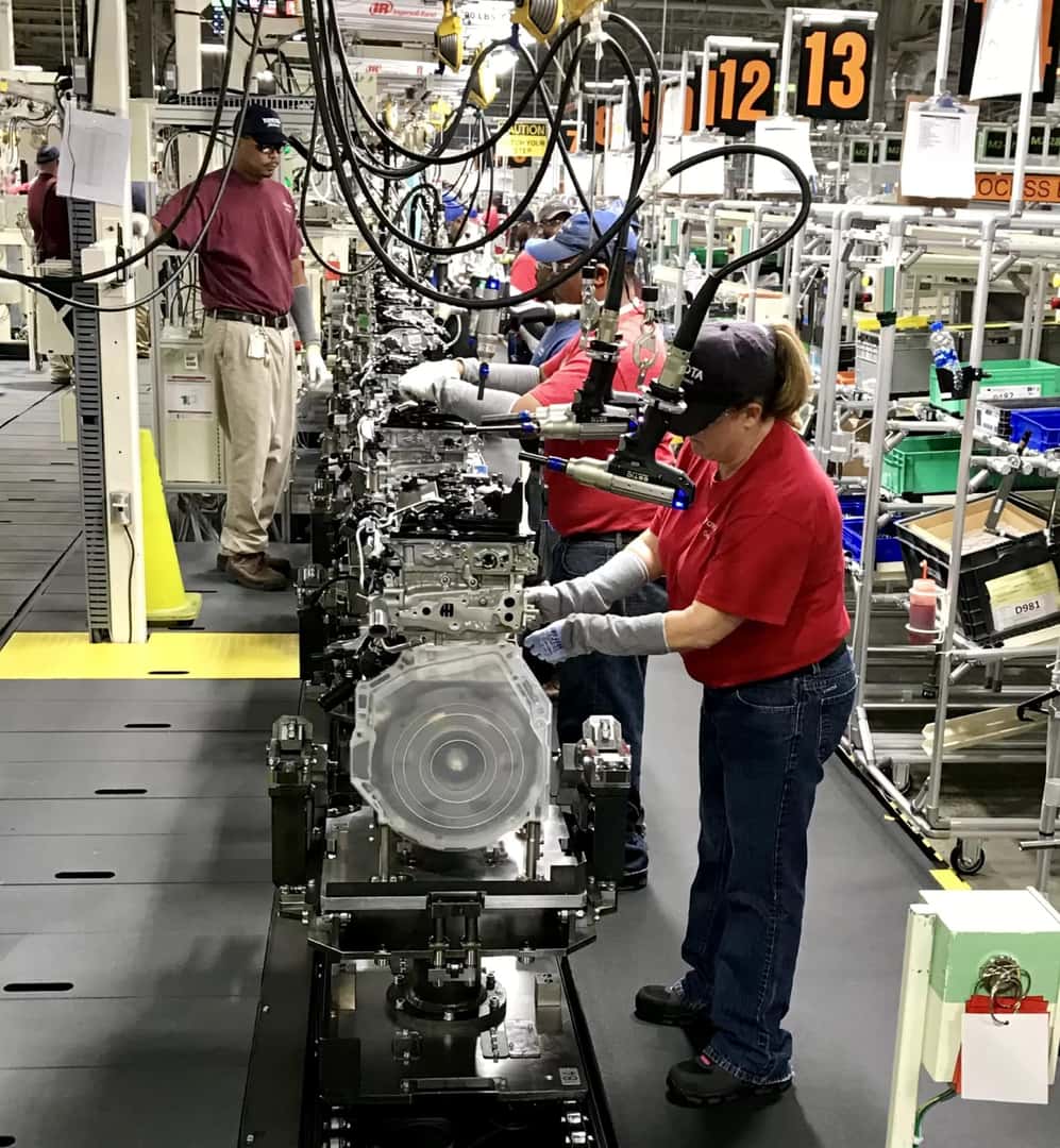 Multiple Dedicated Workers Working On Assembling An Engine At The Toyota Engine Assembly Plant In Huntsville, Alabama
