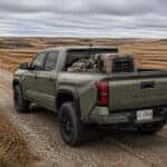 2026 Toyota Tacoma on a South Dakota prairie field road during hunting season with hunting gear in the bed