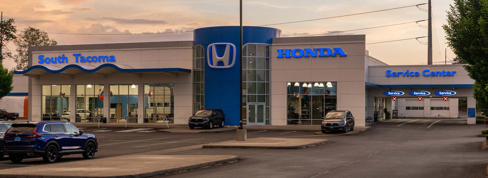 An exterior shot of a Honda dealership at night.