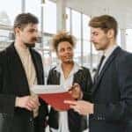 A couple and a salesman looking over paperwork