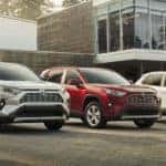 woman walking beside 3 2020 Toyota Rav4 models