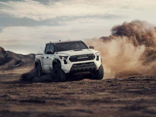 2024 Toyota Tacoma driving fast through dirt with dust cloud