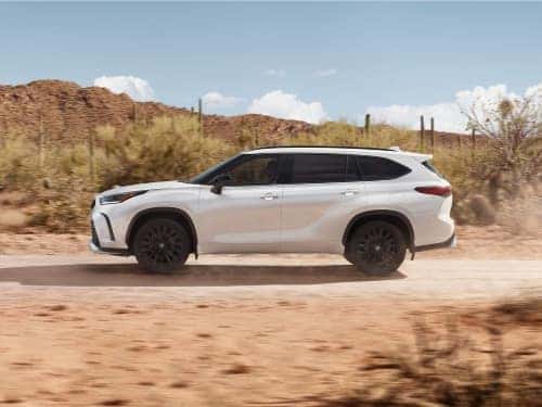 2024 Toyota Highlander side view of vehicle driving in a desert area