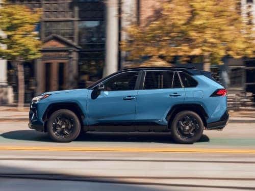 2024 Toyota RAV4 Hybrid driving down a city street