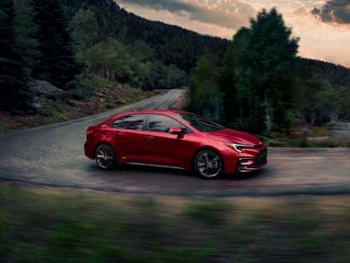 2024 Toyota Corolla Hybrid driving down a windy, mountain road