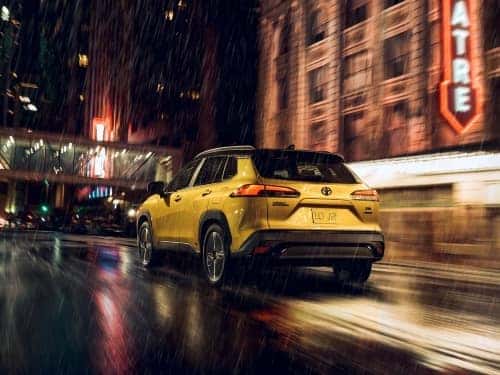 2024 Toyota Corolla Cross driving in the rain through a city street