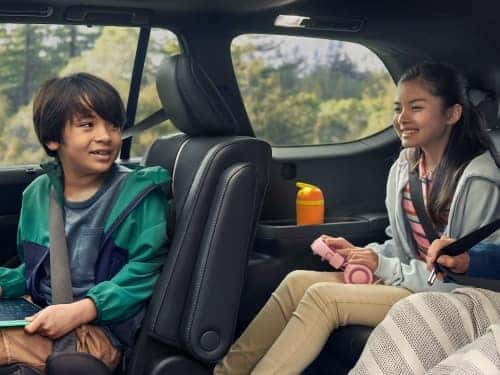 2024 Grand Highlander interior view of two children sitting in middle and back seats