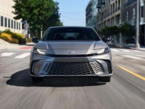 2025 Toyota Camry front exterior view of car driving through a city